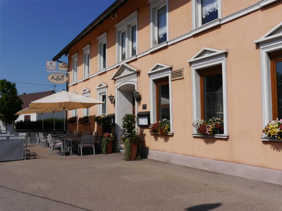Der Gasthof Adler mit Sonnenschirm über der Terrasse und dem Vorplatz